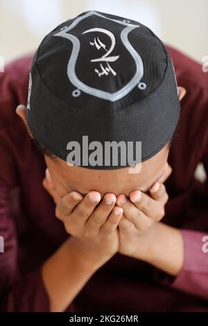 Muslimischer Junge, der einen kufi trägt. Freitagsgebet (Salat) in der Moschee. Chau Doc. Vietnam. Stockfoto