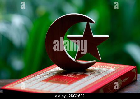 Heiliger Koran mit islam-Halbmond und Stern. Islamisches Symbol. Stockfoto