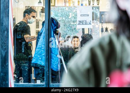 Epsom, Surrey, London, UK, November 19 2022, ehrliche Darstellung eines Mannes, der in Einem Friseurladen sitzt und einen Haarschnitt durch das Schaufenster nimmt Stockfoto