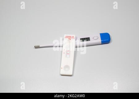 Positiver Test auf Coronavirus-Symptome des Virus auf der Temperatur des Thermometers mit COVID Stockfoto