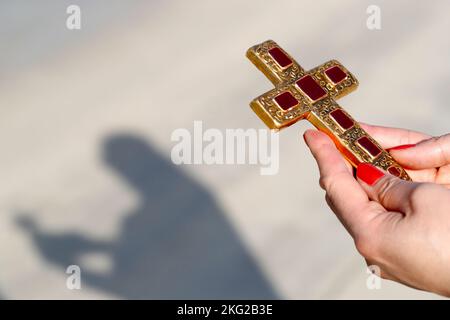 Christliche Frau mit einem christlichen Kreuz. Nahaufnahme der Hände. Konzept für Religion, Glauben, Gebet und Spiritualität. Stockfoto