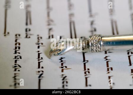 Nahaufnahme des traditionellen Torah-Buchs und des yad in der Synagoge. Tora-Lesung. Stockfoto
