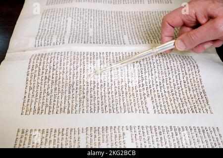 Rabbin hält einen yad in der Hand und liest eine uralte Tora-Schriftrolle. Yom Kippur. Stockfoto