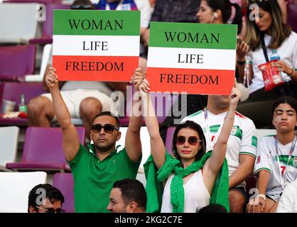 Iranische Fans auf den Tribünen halten vor dem Spiel der FIFA-Weltmeisterschaft der Gruppe B im Khalifa International Stadium in Doha Schilder mit der Aufschrift „Woman Life Freedom“ hoch. Bilddatum: Montag, 21. November 2022. Stockfoto