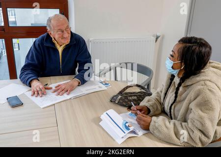 Volunteer hilft einer Migrantin bei ihrer Jobsuche bei La Maison Bakhita, Paris, Frankreich Stockfoto