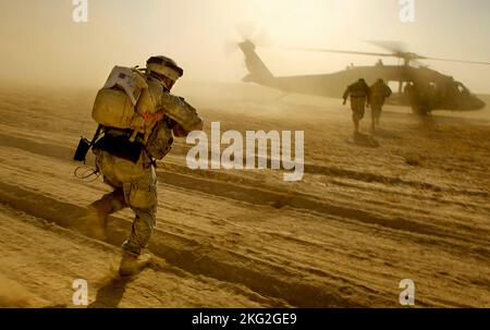 TAL AFAR, IRAK - 05. Juni 2006 - Soldaten der US-Armee laufen auf einen UH-60 Blackhawk-Hubschrauber zu, während sie nach einer Mission in der Nähe von Tal AF extrahiert werden Stockfoto