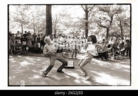 Ein Mann tanzt mit einer viel jüngeren Frau zu den Klängen der 9. Street Stompers Jazzband. Im Central Park in Manhattan um 1978. Stockfoto