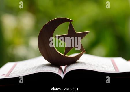 Heiliger Koran mit islam-Halbmond und Stern. Islamisches Symbol. Stockfoto