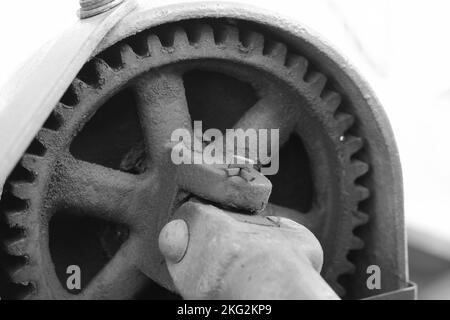 Vintage mechanische Maschine und Motor mit Ketten und Zahnrädern in schwarz-weiß einfarbig. Stockfoto