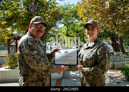 UNTERSTÜTZUNG DER MARINE SOUDA BAY, Griechenland (Okt 25, 2022) Logistikspezialistin der Klasse 1. Brianna Glynn, die der Naval Support Activity (NSA) Souda Bay, Griechenland, zugewiesen wurde, erhält während einer Wiederzuteilungszeremonie am 25. Oktober 2022 vom Chief Warrant Officer Jeremy Mott eine Wiederzuteilungsbescheinigung. NSA Souda Bay ist ein operativer Stützpunkt an Land, der es den US-, Alliierten- und Partnernationstruppen ermöglicht, dort zu sein, wo sie gebraucht werden, um die Sicherheit und Stabilität in den Verantwortungsbereichen der europäischen, afrikanischen und zentralen Kommandos zu wahren. Stockfoto