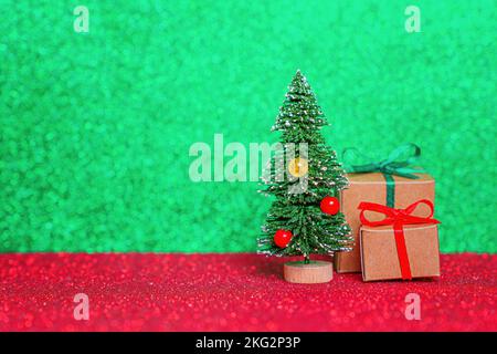 Miniatur-Weihnachtsbanner: Geschenkschachteln von einem Weihnachtsbaum vor einem lebhaften Hintergrund eingewickelt. Stockfoto