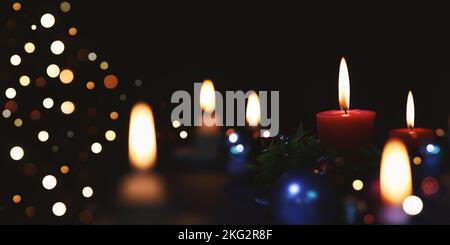 Glitzernde Kirchendekorationen, hell beleuchtete Kerzen und heller Hintergrund zur Feier der Weihnachten Jesu Christi Stockfoto