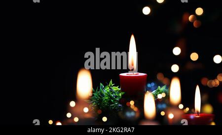 Glitzernde Kirchendekorationen, hell beleuchtete Kerzen und heller Hintergrund zur Feier der Weihnachten Jesu Christi Stockfoto