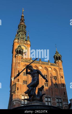 Der Neptunbrunnen und das Rathaus bei Sonnenuntergang in der Stadt Danzig, Polen. Historische Sehenswürdigkeiten in manieristischen Rokoko (Brunnen) und Gotik und Stockfoto
