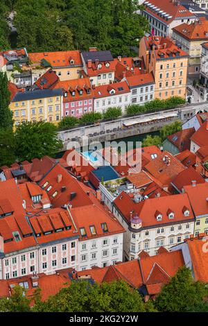 Stadt Ljubljana in Slowenien, Blick über rot geflieste Häuser auf beiden Seiten des Flusses Ljubljanica in der Altstadt. Stockfoto