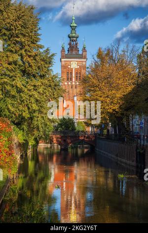 Herbst am Radunia-Kanal mit Blick auf die St. Katharinenkirche in der Stadt Danzig in Polen. Stockfoto