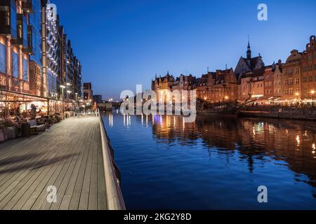 Stadt Danzig bei Nacht in Polen, Promenade entlang des Motlawa Flusses und Blick auf die Altstadt Skyline am Abend. Stockfoto