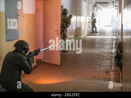 NATO verstärkte Präsenz Kampfgruppe Polen Soldaten zugewiesen Chaos Company, 3. Bataillon, 8. Kavallerie-Regiment, 3. Panzerbrigade Kampfteam, 1. Kavallerie Division (3-1 ABCT), Zusammen mit den polnischen Streitkräften verteidigen 5. Masowische Brigade der Territorialen Verteidigung ihren Posten mit Gummiballmunition vor simulierten Angriffen während des städtischen Einsatztrainings in Komorowo, Polen, 26. Oktober 2022. Die 3-1 ABCT ist unter anderem der 1. Infanterie-Division zugeordnet und arbeitet stolz mit NATO-Verbündeten und regionalen Sicherheitspartnern zusammen, um dem V Corps, Ameri, kampfglaubwürdige Streitkräfte zur Verfügung zu stellen Stockfoto