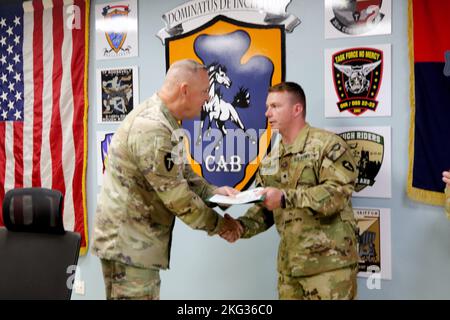 SPC der US-Armee. Damon Swanson, Hubschrauber-Werkstatt UH-60 Black Hawk, 15T, für 2. Bataillon, 149. Aviation Regiment, General Support Aviation Bataillon, 36. Combat Aviation Brigade, „Task Force Mustang“, 36. Infantry Division (rechts), erhält Glückwünsche von Command Sgt. Maj. Robert W. Hartzog, Kommandofeldwebel Major der Task Force Mustang, während eines Befehls- und Mitarbeitertreffens im Hauptquartier der Task Force Mustang im Lager Buehring, Kuwait, am 26. Oktober 2022. Swanson, der aus Conway, Arkansas, stammt, wurde für seine jüngsten Performance-Reviews als „Held der Woche“ der Task Force Mustang ausgezeichnet Stockfoto