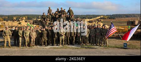 Soldaten der US-Armee, die dem Kampfteam der Panzerbrigade 3., der Kalvariendivision 1. und polnischen Soldaten der gepanzerten Kavalleriedivision Lubuska 11. zugewiesen sind, machen ein Gruppenfoto beim Abrams-Logistikgipfel auf der DPTA, Polen, 26 2022. Oktober. Die 3-4 ABCT ist unter anderem der 1. Infanterie-Division zugeordnet und arbeitet stolz mit NATO-Verbündeten und regionalen Sicherheitspartnern zusammen, um dem V Corps, Amerikas vorwärts entsandt Korps in Europa, kampfglaubwürdige Streitkräfte zur Verfügung zu stellen. Stockfoto