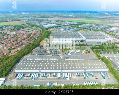 Drohnenaufnahme der Immobilienzone mit Grünflächen und vielen in der Laderampe geparkten Lastwagen Stockfoto