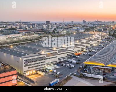 Drohnenaufnahme eines Industriegebiets mit Parkplatz und LKW-Ladedock in der seine Saint Denis, Frankreich Stockfoto