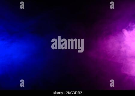 Rauch in blauem und violettem Neonlicht, das sich auf schwarzem Tischhintergrund mit Reflexion dreht Stockfoto