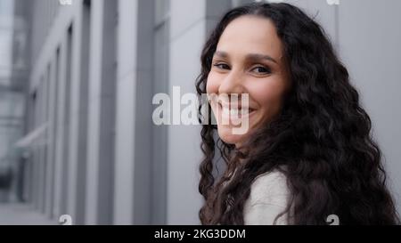 Close-up Rückansicht 30s glücklich lächelndes Mädchen Frau Hispanic Latein kaukasischen Dame Geschäftsfrau Tourist in der Stadt im Freien drehen sich um zu sehen Stockfoto