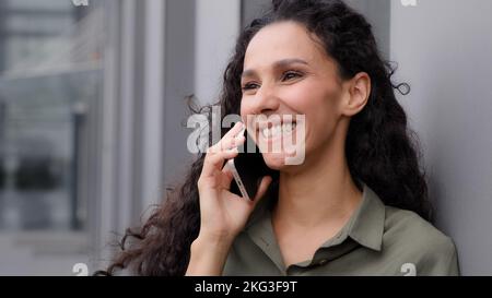 Fröhlich lachend lächelnd glücklich unbeschwert Frau telefonieren hören gut Sieg Nachrichten sagen wow Reaktion Überraschung erstaunlich Wunder Ausdruck Stockfoto