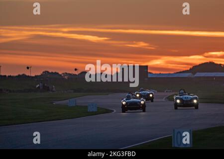 Das Freddie March Memorial Trophy-Rennen bei Sonnenuntergang, ein einstündiges Rennen mit zwei Fahrern im Goodwood Revival Stockfoto