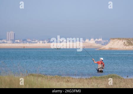 Fliegenfischen in den idyllischen Gewässern des Hafens von Pagham in West Sussex vor dem Hintergrund von Bognor Regis. Stockfoto