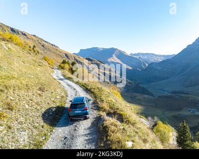 Ein Auto, das von einem riskanten Pfad auf einer einzigen Bergstraße über den Hügel in Ostfrankreich vorbeifährt. Stockfoto