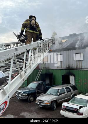 Ein Feuerwehrmann, der der Feuerwehr Duluth zugewiesen wurde, reagiert auf einen Strukturbrand während einer Live-Brandentwicklung im Emergency Response Training Center der Lake Superior College, Duluth, Minnesota, am 27. Oktober 2022. Die Feuerwehr 148., die Feuerwehr Duluth und die höhere Feuerwehr haben gemeinsam einen zweiwöchigen, praktischen Abschlusskurs veranstaltet, der den neuen Feuerwehrleuten helfen soll, in ihrer neuen Karriere erfolgreich zu sein und Trainingspläne für die Feuerwehr in der Region zu standardisieren. (Foto der Air National Guard von Audra Flanagan) Stockfoto