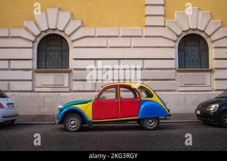 Farbenfroher und eigenartiger, individueller Volkswagen-Käfer, der an einer Kopfsteinpflasterstraße in Rom, Italien, parkt. Klassisches Auto in einprägsamen Farbblöcken. Stockfoto