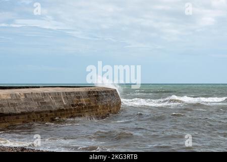 Wellen Sie über den weltberühmten Cobb bei Lyme Regis Dorset England, der in Jane Austens Roman Persuasion zu sehen ist Stockfoto