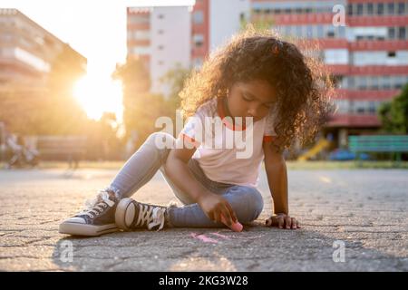 Nettes Kind in einer kreativen Aktivität im Freien engagiert Stockfoto