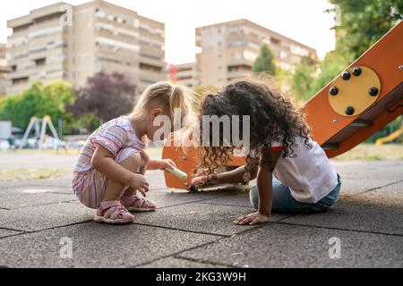 Zwei Kinder nahmen an einer kreativen Aktivität auf dem Spielplatz Teil Stockfoto