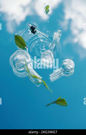 Verschiedene Laborgläser mit Bio-Pflanzen liegen auf einem Wasserhintergrund mit blauer Himmelssinnung. Wissenschaftliche Laborforschung und -Entwicklung Stockfoto