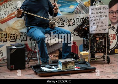 Hongkong, China. 19.. November 2022. Ein Musiker spielt „Ruhm für Hongkong“ und „Sing du hier die Leute?“ Auf einem Erhu vor der Quarry Bay Station in Hongkong. „Glory to Hong Kong“, die als inoffizielle Hymne der Pro-Demokratie-Proteste von 2019 gilt, hat in letzter Zeit Schlagzeilen gemacht, da sie bei zahlreichen internationalen Rugby-Veranstaltungen mit der tatsächlichen chinesischen Nationalhymne verwechselt wurde. In Hongkong bestehen nach wie vor Fragen nach der Rechtmäßigkeit des öffentlichen Spielens oder Aufführens dieses Liedes gemäß dem nationalen Sicherheitsgesetz. (Foto von Ben Marans/SOPA Images/Sipa USA) Quelle: SIPA USA/Alamy Live News Stockfoto