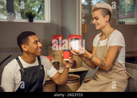 Romantisches biracial Paar toasting zu ihrem Start Stockfoto