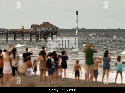 SpaceX Crew-5 der NASA. Strandbesucher beobachten, wie der Raketenbooster Falcon 9, der für den Start der NASA SpaceX Crew-5 verwendet wird, auf dem autonomen Raumhafen-Drohnenschiff (ASDS) sitzt, am Samstag, den 8. Oktober 2022, in Cape Canaveral nach Port Canaveral geschleppt wird. Florida. Die NASA-Mission SpaceX Crew-5 ist die fünfte Rundungsmission der Raumsonde SpaceX Crew Dragon und der Falcon 9-Rakete zur Internationalen Raumstation im Rahmen des Commercial Crew Program der Agentur. Die NASA-Astronauten Nicole Mann und Josh Cassada, der Astronaut Koichi Wakata von der Japan Aerospace Exploration Agency (JAXA) und die Kosmonautin Anna Kikin von Roskosmos Stockfoto