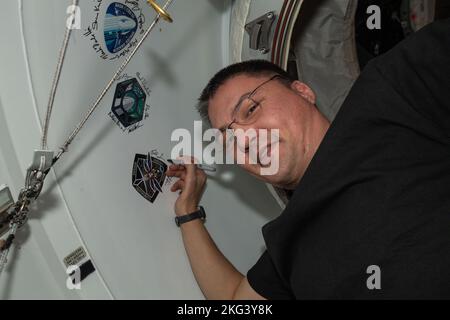 . Iss068e016454 (Okt 12, 2022) --- NASA-Astronaut und Expedition 68-Flugingenieur Kjell Lindgren, ebenfalls Kommandant der SpaceX Crew-4, signiert seinen Namen um die Crew-4-Missionsinsignien, die am Vestibül zwischen dem Weltraumhafen des Harmony-Moduls und dem Dragon Freedom-Besatzungsschiff angebracht sind. Stockfoto