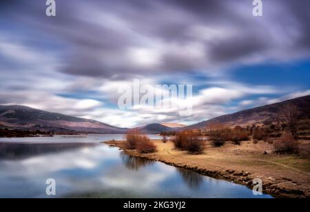 Schnelle Wolken über dem Reservoir Pinilla del Valle in der Provinz Madrid. Stockfoto