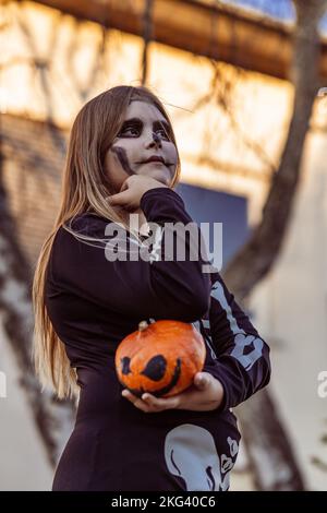 Kinder feiern eine Halloween-Kostümparty im Garten Stockfoto