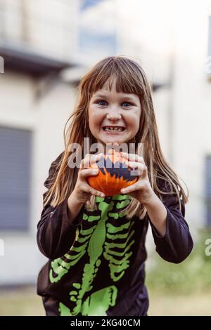 Kinder feiern eine Halloween-Kostümparty im Garten Stockfoto