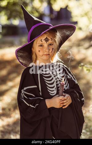 Kinder feiern eine Halloween-Kostümparty im Garten Stockfoto