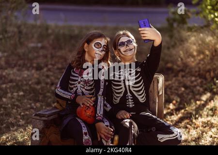 Kinder feiern eine Halloween-Kostümparty im Garten Stockfoto