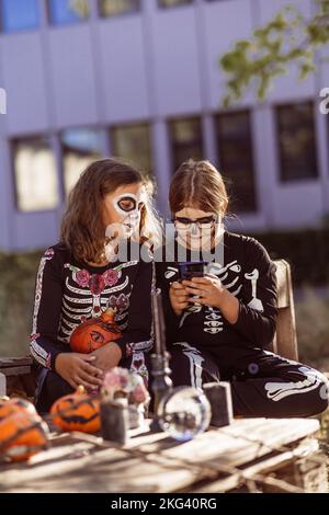 Kinder feiern eine Halloween-Kostümparty im Garten Stockfoto