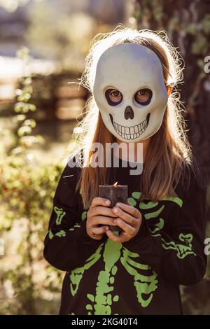 Kinder feiern eine Halloween-Kostümparty im Garten Stockfoto