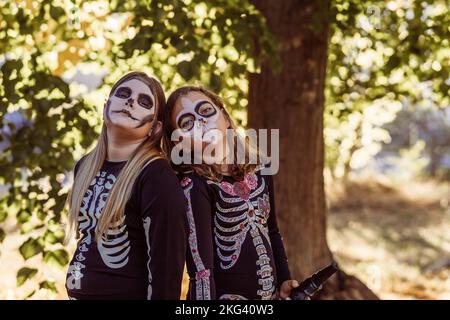 Kinder feiern eine Halloween-Kostümparty im Garten Stockfoto